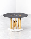 Richard Yasmine Glory Holes Side Table featuring a round charcoal tabletop with circular cutouts, supported by slender gold-tone vertical rods and a contrasting white circular base. Its sculptural construction and metallic detailing create a distinctive contemporary accent.