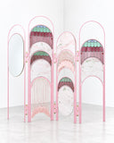 Richard Yasmine Hawa Paravent featuring a series of pink arched panels with intricate decorative patterns and contrasting turquoise details. Its rhythmic shapes and ornamental design create a sculptural room divider for expressive contemporary interiors.