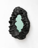 Richard Yasmine Silent Hollows Large Wall Mirror featuring an irregular reflective centre surrounded by a dramatic, crumpled black sculptural frame. Its organic contours and textured appearance transform a functional mirror into a distinctive wall statement.