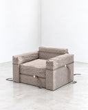 Richard Yasmine Size Matters Armchair featuring a compact, block-like silhouette with thick upholstered seat and back cushions in a neutral textured fabric. Its exaggerated proportions and low profile give the chair a relaxed, contemporary character.