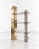 Richard Yasmine Size Matters Bookshelf featuring an asymmetrical vertical frame with staggered shelves in contrasting metallic and warm-toned finishes. Its unconventional proportions and sculptural arrangement create a distinctive contemporary storage feature.
