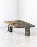 Richard Yasmine Size Matters Dining Table featuring a rectangular top with striking blue, green, and warm-toned patterning, supported by substantial sculptural legs. Its expressive surface and bold proportions bring an artistic statement to contemporary dining interiors.