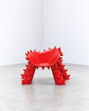 Ryan Mercer Becareful Chair featuring a vivid red finish, angular legs, and a spiked sculptural silhouette. Its unconventional form and bold character make it a striking statement piece for contemporary interiors.