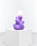 Ryan Mercer Blamp Table Lamp featuring a playful stack of rounded purple forms topped with a spherical light. Its sculptural composition and contrasting shapes create a distinctive decorative lighting accent.