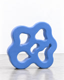 Ryan Mercer Blob Shelf Sr featuring a bold blue frame with irregular curves and multiple organically shaped openings. Its larger sculptural profile makes a distinctive contemporary wall-storage feature.