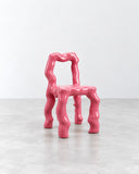Ryan Mercer Melt Chair featuring a glossy hot-pink finish and an irregular, fluid frame with rounded contours. Its distinctive sculptural construction gives this contemporary chair a playful, art-inspired presence.