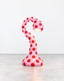 Ryan Mercer Tentacle Lamp featuring a curving red sculptural form covered in contrasting circular details. Its fluid, tentacle-inspired silhouette and bold pattern create an expressive statement in contemporary lighting design.