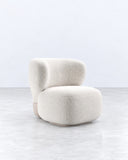 Asawa lounge chair featuring a generously padded ivory upholstered seat and rounded backrest with an organic silhouette. Its low-profile construction emphasizes soft geometry and contemporary comfort.