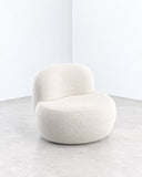 B15Z lounge chair featuring a softly rounded upholstered seat and curved backrest in a warm ivory fabric. Its compact, sculptural silhouette combines plush comfort with minimalist contemporary design.