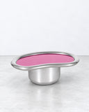 SECOLO X EERA Laghi M coffee table featuring a pink circular tabletop with a reflective metallic rim and a cylindrical silver pedestal base. The contrast between the vibrant surface and polished metal creates a distinctive contemporary accent.