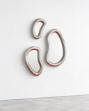 SECOLO x EERA Laghi wall mirror featuring three irregular reflective loops connected in an organic sculptural composition. Its fluid metallic outline creates a distinctive contemporary mirror with a minimalist aesthetic.