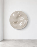 Frame Round Freeform wall object featuring a circular ivory surface with raised organic relief and a softly irregular sculptural texture. Its glossy finish and dimensional pattern create a distinctive contemporary wall accent.
