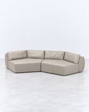 Futura sofa featuring a generously cushioned sectional configuration in neutral beige upholstery, with softly rounded corners and a low profile. Its clean modular geometry suits contemporary residential and hospitality interiors.