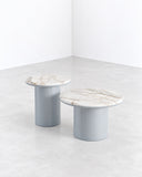 SECOLO Gemini Round Coffee Table featuring circular stone tops with natural veining and rounded cylindrical bases in a soft blue-grey finish. Its sculptural silhouette combines understated elegance with contemporary design.