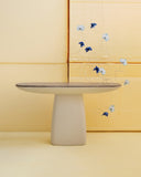 HERA X sculptural console featuring a dark stone surface and substantial light-toned pedestal base. The refined geometric form brings a contemporary architectural character to residential and hospitality interiors.