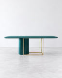 SECOLO Horus Marble Dining Table featuring a slim, rounded teal tabletop supported by a sculptural teal pedestal and a contrasting slender gold-tone metal frame. Its bold colour and geometric base bring distinctive character to contemporary dining spaces.