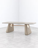 Inge dining table featuring a slim, organically shaped pale tabletop supported by sculptural light-toned pedestal legs. Its rounded contours and minimalist construction create a refined contemporary dining centerpiece.