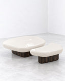 Kawa coffee table featuring two low, organically shaped pale tabletops supported by compact rounded bases. The smooth surfaces and fluid contours create a sculptural contemporary table set.