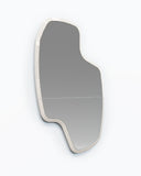 Sculptural LAB L wall mirror featuring an organically irregular silhouette and slim light-toned frame. The asymmetrical form brings a refined architectural character to contemporary interiors.