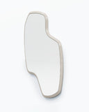 Vertical LAB L wall mirror featuring a freeform silhouette and softly rounded contours within a slim light-toned frame. The sculptural profile combines functional reflection with contemporary design.