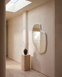 LAB L organic wall mirror showcasing an irregular sculptural frame and elongated reflective surface. The minimalist design creates an elegant architectural accent in contemporary interiors.