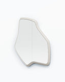 Contemporary LAB M mirror featuring an organically irregular reflective surface surrounded by a slim light-toned frame. The fluid silhouette adds architectural character to modern interiors.