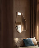 Sculptural LAB M mirror featuring a freeform reflective surface and softly rounded light-toned frame. The versatile wall piece adds depth and an organic contemporary character to interior spaces.
