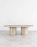 SECOLO Laghi II Dining Table featuring a slim oval tabletop and two substantial cylindrical legs in a soft beige finish. Its balanced proportions and understated sculptural form suit refined contemporary dining environments.