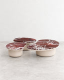 SECOLO Laghi X Coffee Tables featuring a set of round burgundy marble tops with expressive white veining and rounded cream-toned bases. The contrasting colours and varied heights create a striking sculptural arrangement for luxury living spaces.