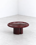 SECOLO Moonrise Coffee Table with a deep burgundy circular top featuring natural stone-like veining and a matching sculptural pedestal base. Its rich colour and compact, rounded form make a bold contemporary statement.