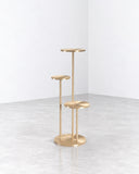 Orion side table featuring a slender gold-toned metal frame with a series of small circular platforms arranged at different heights. Its vertical open structure creates a sculptural contemporary accent for compact interiors.