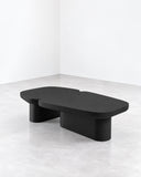 SECOLO Pangea Coffee Table featuring a dark, softly rounded tabletop and substantial sculptural supports in a matte black finish. Its low-profile silhouette and minimalist geometry suit contemporary residential and hospitality interiors.