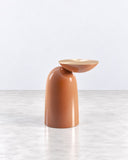 Pingu side table featuring a glossy terracotta-colored sculptural body with a rounded top and integrated curved form. Its playful silhouette and smooth finish create a distinctive contemporary accent table.