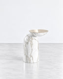 Pingu X side table featuring a sculptural white stone body with expressive grey veining and an organically curved profile. The smooth natural surface and fluid silhouette create a refined contemporary accent.