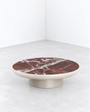 SECOLO Romo Coffee Table featuring a round burgundy marble top with expressive white veining and a rounded metallic-finish pedestal base. Its rich stone pattern and restrained silhouette bring understated luxury to modern interiors.