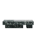 Close-up of the THERRA coffee table showcasing richly veined green stone and its geometric recessed base. The natural stone surface contrasts with the precise architectural construction.