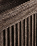 Close-up of the THERRA console highlighting the layered texture of its travertine surface and vertically fluted stone base. The tactile detailing emphasizes the craftsmanship of this architectural furniture piece.