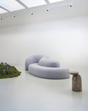Sculptural TRACE ISLAND sofa composed of curved upholstered modules with rounded edges and a low, expansive profile. Its organic geometry creates a versatile statement piece for contemporary hospitality and residential interiors.