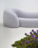 Close-up of the TRACE ISLAND sofa showcasing its softly rounded upholstered modules and seamless curved contours. The tactile upholstery emphasizes the sofa's sculptural construction and inviting form.