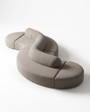 TRACE MODULAR sectional sofa featuring rounded upholstered modules joined into a flowing sculptural composition. Its flexible configuration creates a distinctive seating landscape for contemporary interiors.