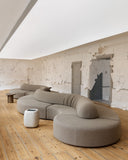 TRACE MODULAR sofa arranged as an expansive composition of rounded upholstered modules. The sculptural sectional design creates a relaxed yet architectural focal point for residential and hospitality spaces.
