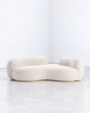 SECOLO sofa featuring a low, cloud-like composition of rounded ivory upholstered cushions and curved seating modules. The soft organic forms create a relaxed contemporary sofa with sculptural appeal.