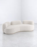 Tateyama XL sofa featuring an expansive arrangement of rounded ivory upholstered cushions and a continuous curved backrest. Its generous proportions and fluid geometry create a statement piece for contemporary living spaces.