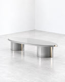 SECOLO Tayma Coffee Table featuring an elongated, softly rounded light-toned top supported by polished cylindrical metal legs. Its clean lines and refined material contrast complement sophisticated contemporary interiors.