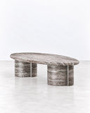 SECOLO Tayma X Coffee Table featuring an elongated oval top with expressive grey and white stone-like veining, supported by two substantial cylindrical legs. Its bold material pattern and minimalist sculptural form create a distinctive focal point in contemporary living spaces.