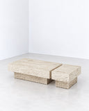 Therra coffee table featuring a rectangular travertine top and block-like stone supports with a naturally textured finish. Its low monolithic form emphasizes the architectural character of natural stone.