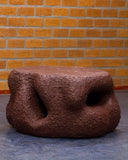 Sculptural coffee table featuring organic carved openings. A handcrafted furniture piece inspired by nature