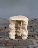Designer stool showcasing organic carved legs and artisan craftsmanship. Created to celebrate the character of natural materials.