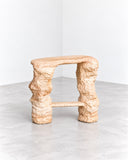Tellurico 2LEGS Mini Stool featuring two chunky, sculptural legs joined by a horizontal support beneath a compact rectangular seat. Its rough, organic surface and playful proportions bring a distinctive artistic character to contemporary interiors.