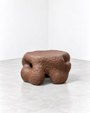 Tellurico Ollain Coffee Table featuring a low, organically contoured silhouette with rounded lobes and a richly textured brown finish. Its compact proportions and irregular sculptural form bring an artistic accent to contemporary interiors.